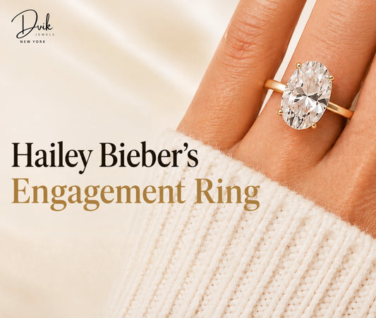 Close-up of an oval cut engagement ring on a hand, captioned as a replica of Hailey Bieber's engagement ring by Dvik Jewels.