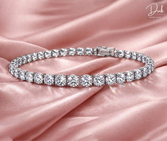 Premium lab grown diamond tennis bracelet by Dvik Jewels with consistent round cut diamonds on pink silk fabric.