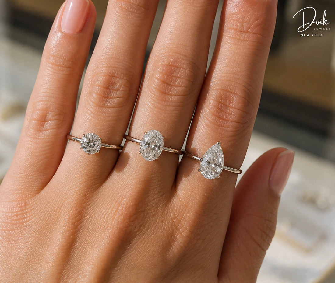 Size comparison of round, oval, and pear-shaped diamond solitaire rings on a hand by Dvik Jewels New York.