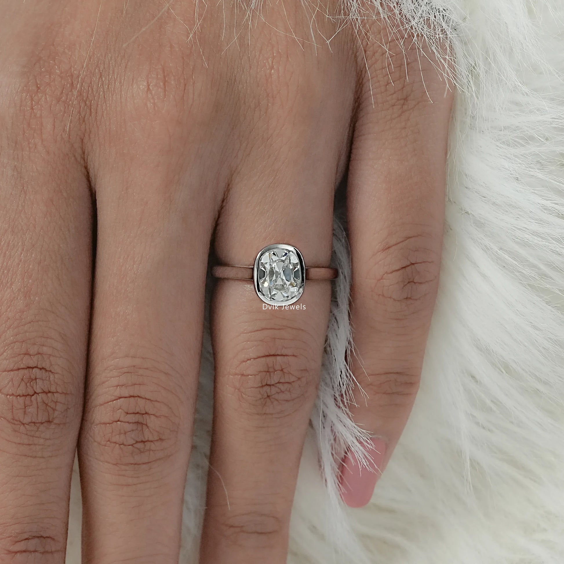 Top view of old mine diamond ring with elongated cushion stone being worn on a finger