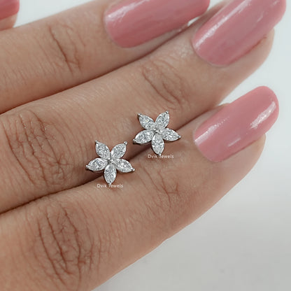 Floral earrings studs with marquise cut diamond held between women’s fingers