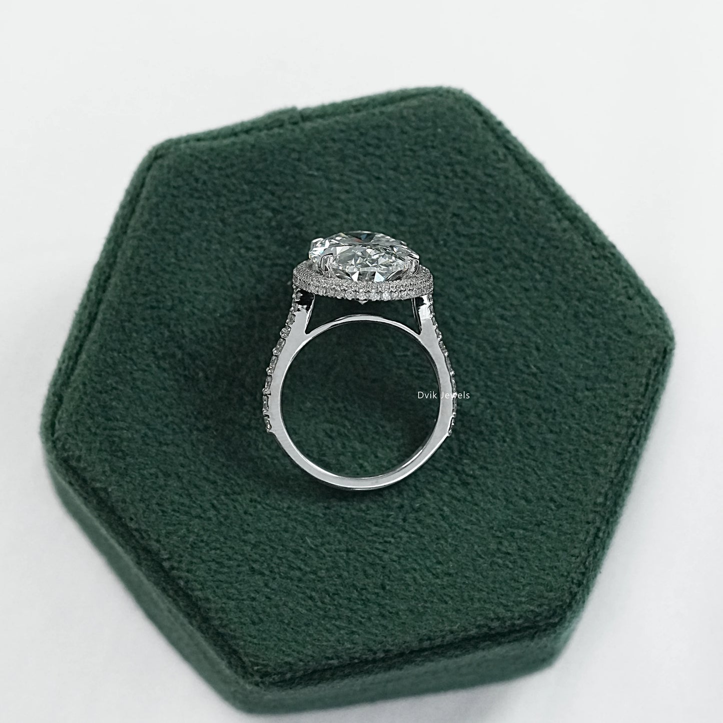 Oval engagement rings with halo displayed on a soft fabric for sharp detail