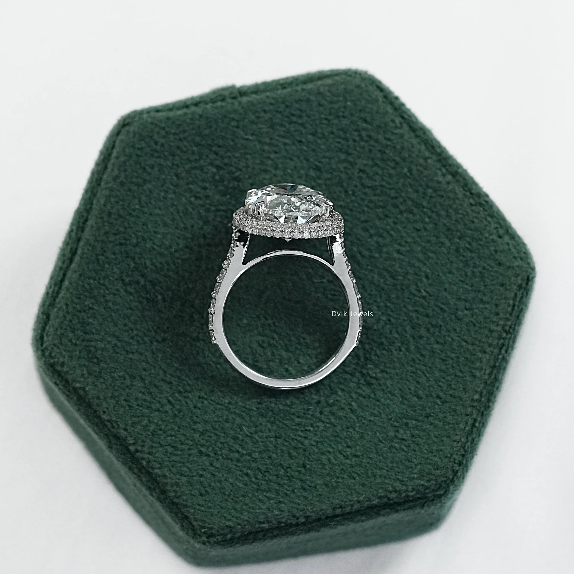 Oval engagement rings with halo displayed on a soft fabric for sharp detail