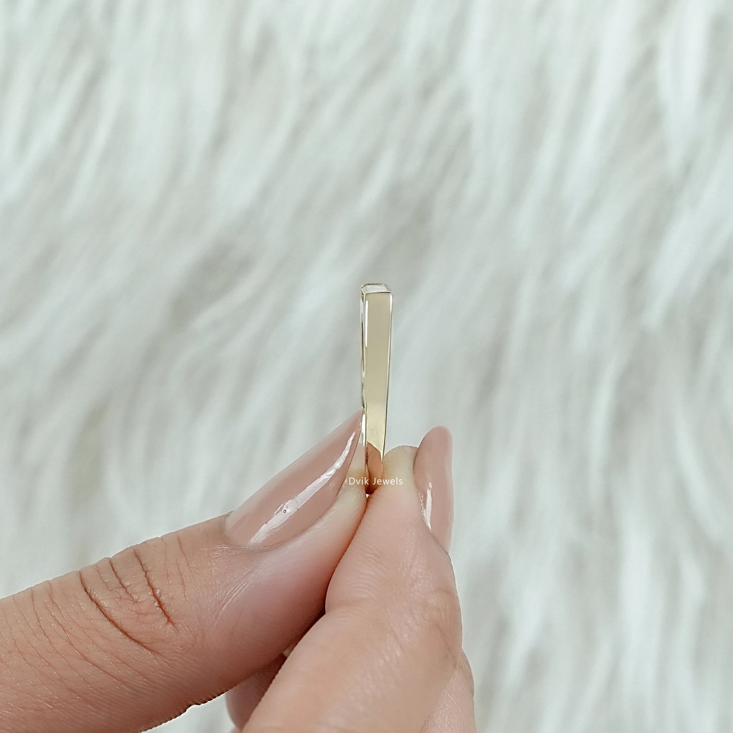 East west baguette engagement ring on a finger with white gold finish