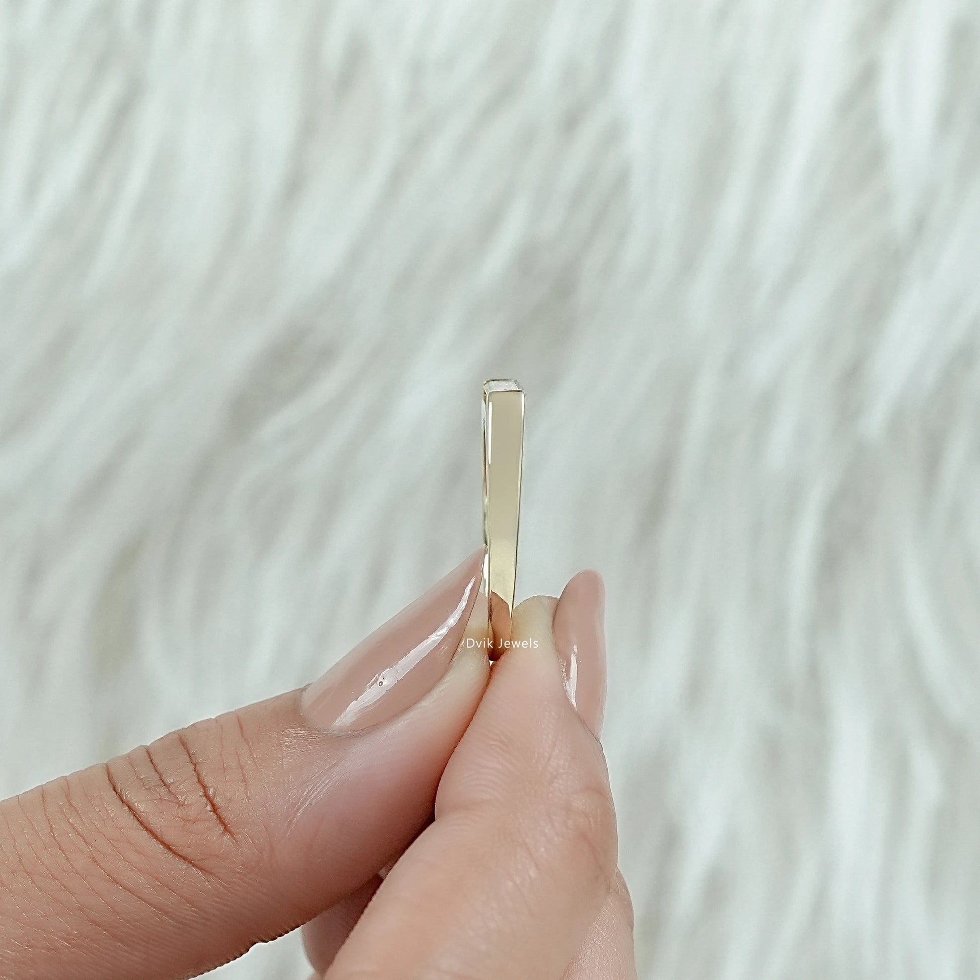 East west baguette engagement ring on a finger with white gold finish