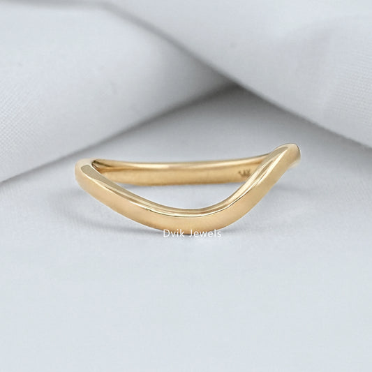 Curved wedding band yellow gold on white fabric background