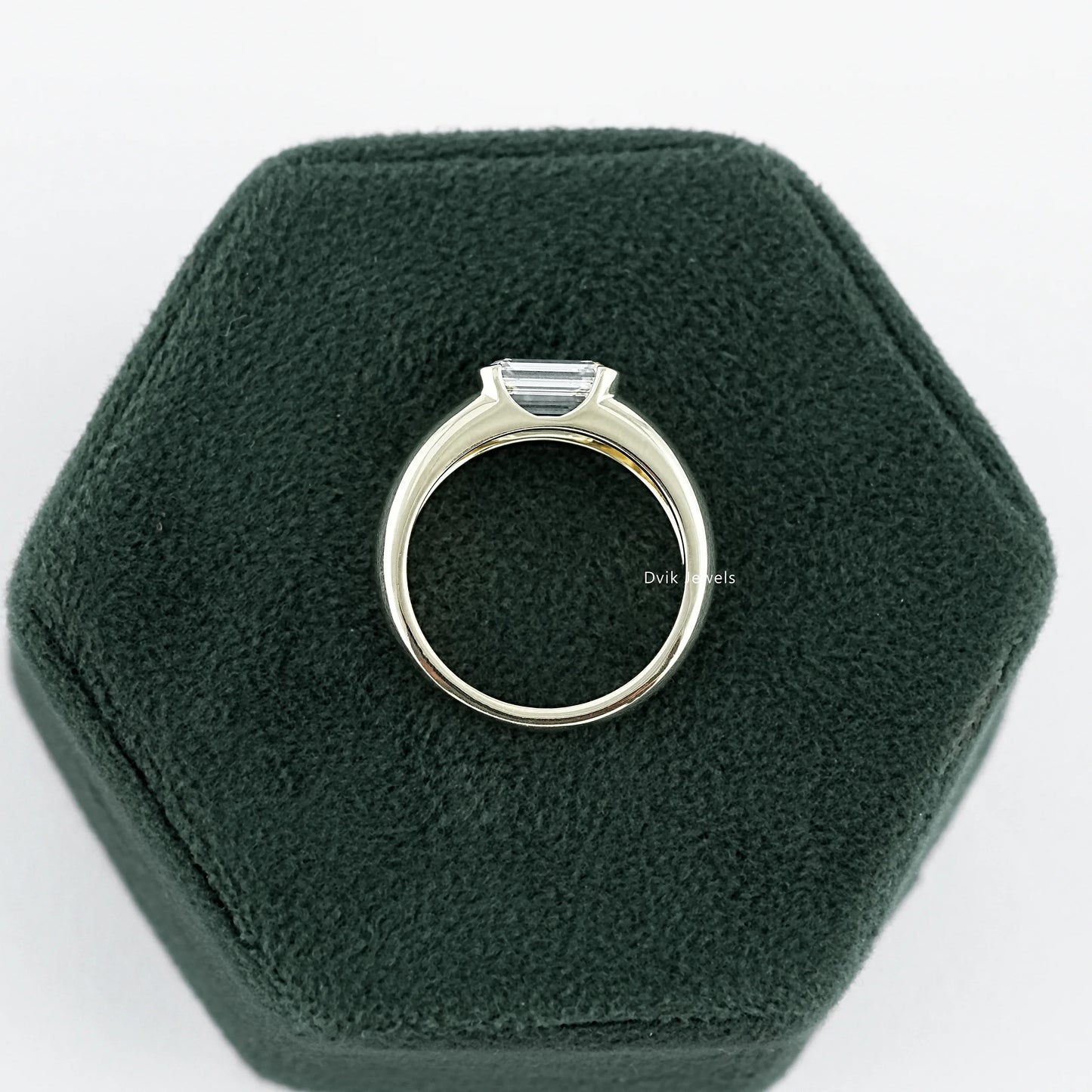 Emerald Cut wide band Solitaire engagement Ring held on jewelry box, ideal for gifting