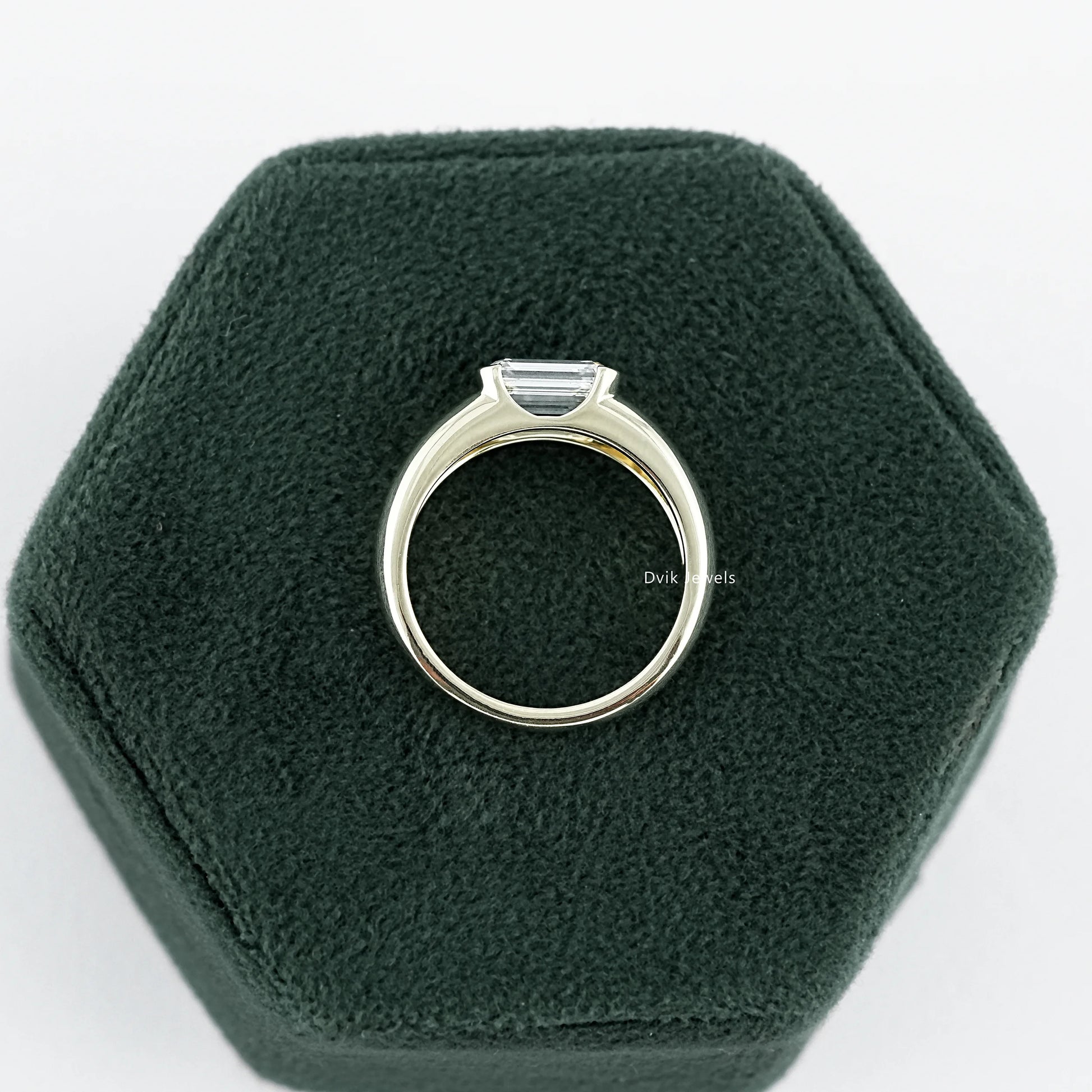 Emerald Cut wide band Solitaire engagement Ring held on jewelry box, ideal for gifting