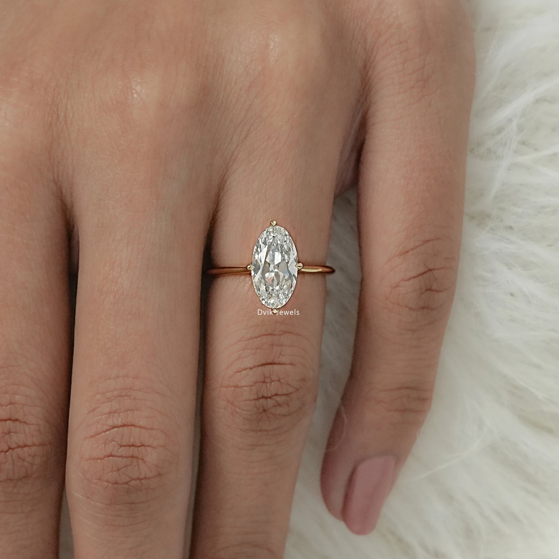 Moval diamond solitaire ring on a finger, showing elongated oval-marquise hybrid shape