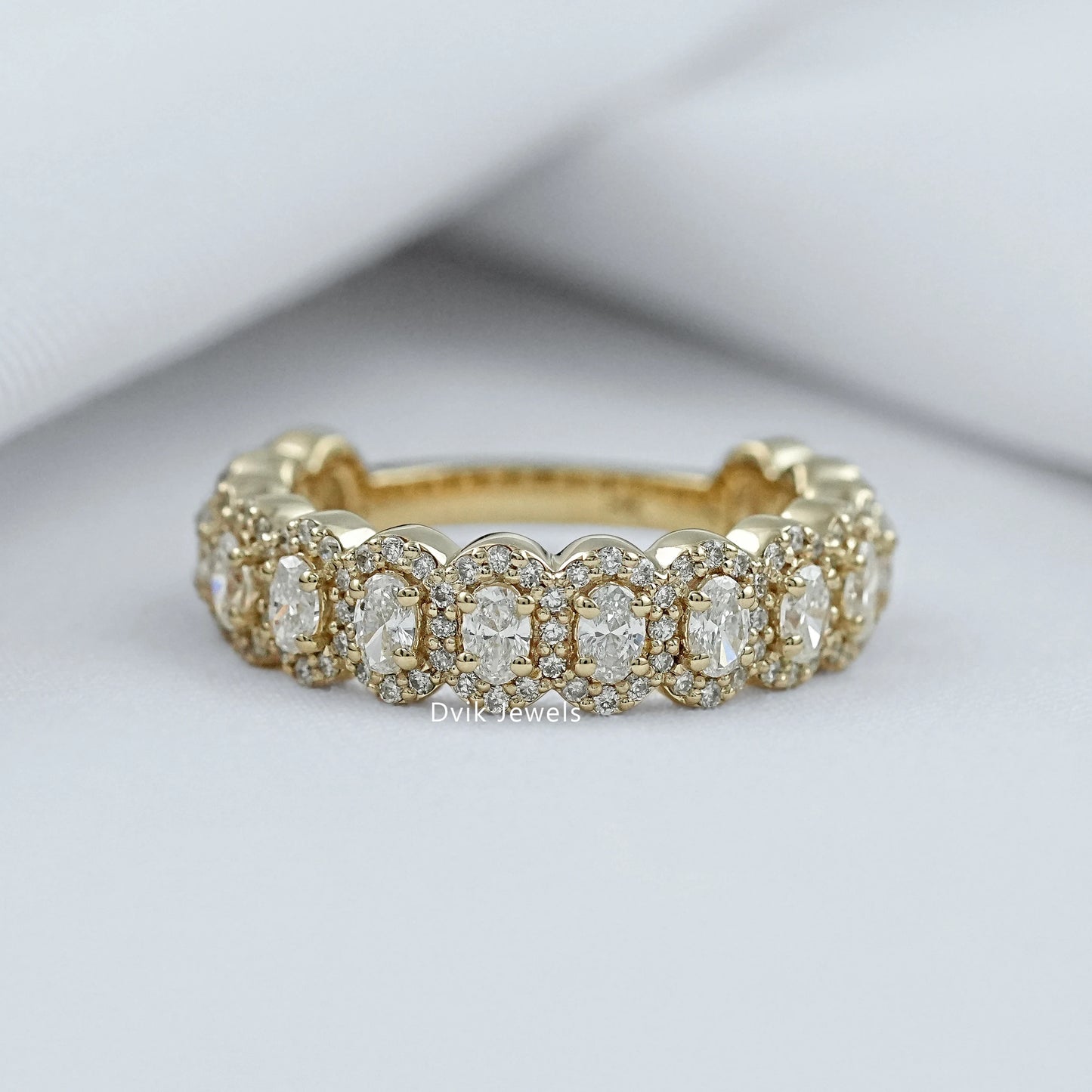Oval halo with wedding band in 14k yellow gold cluster style.