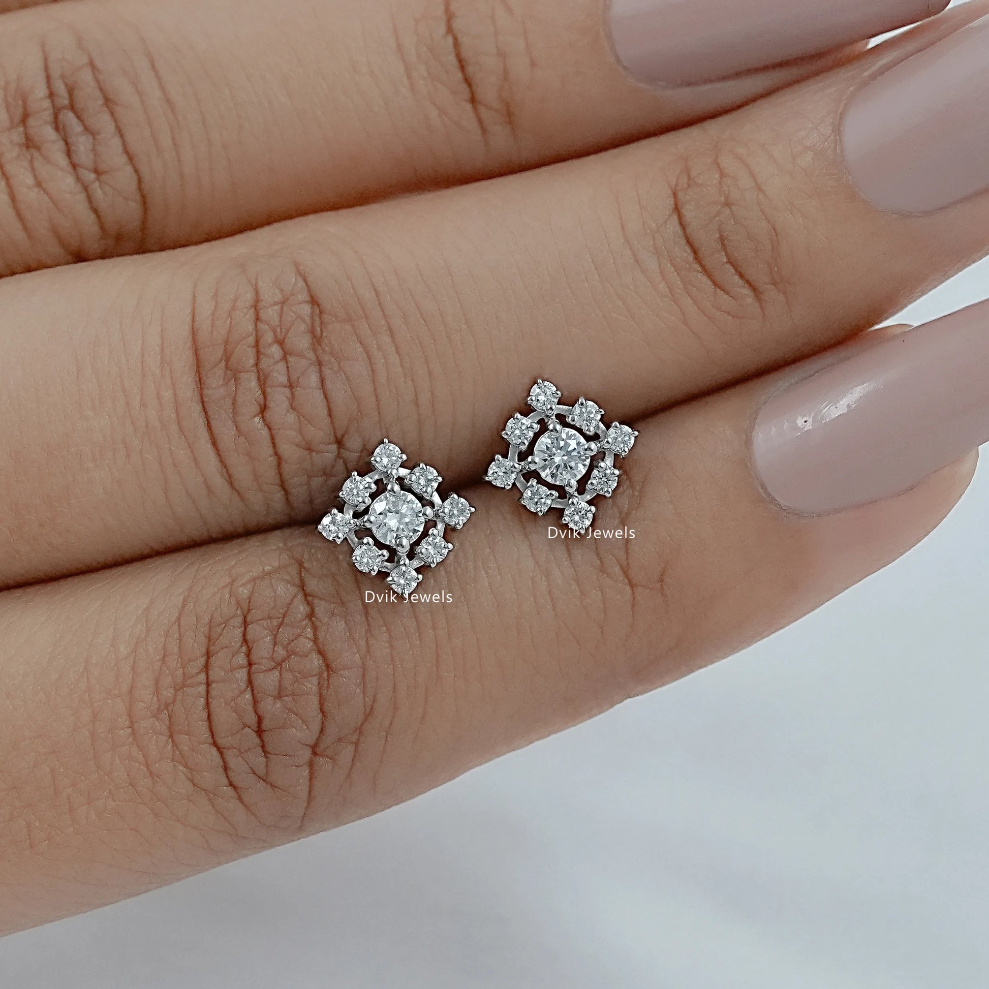 Aerial view of halo diamond earrings 1 ct nestled in a hexagonal green jewelry box.