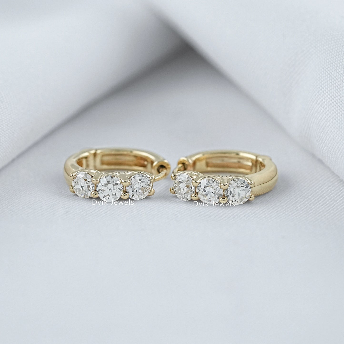 Three stone round cut huggie hoop earrings in yellow gold by Dvik Jewels