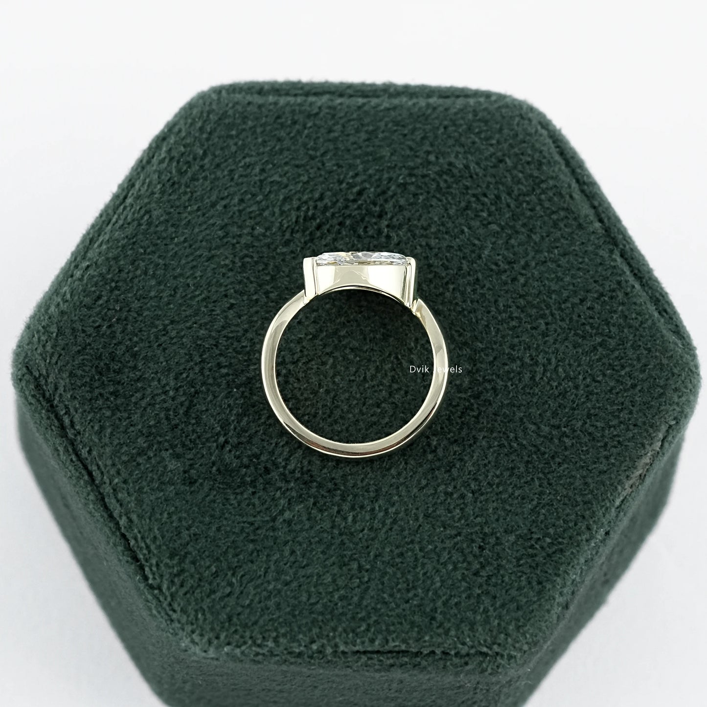 Lab Made Diamond Curved Marquise Cut Solitaire Engagement Ring held on jewelry box displaying mid-profile