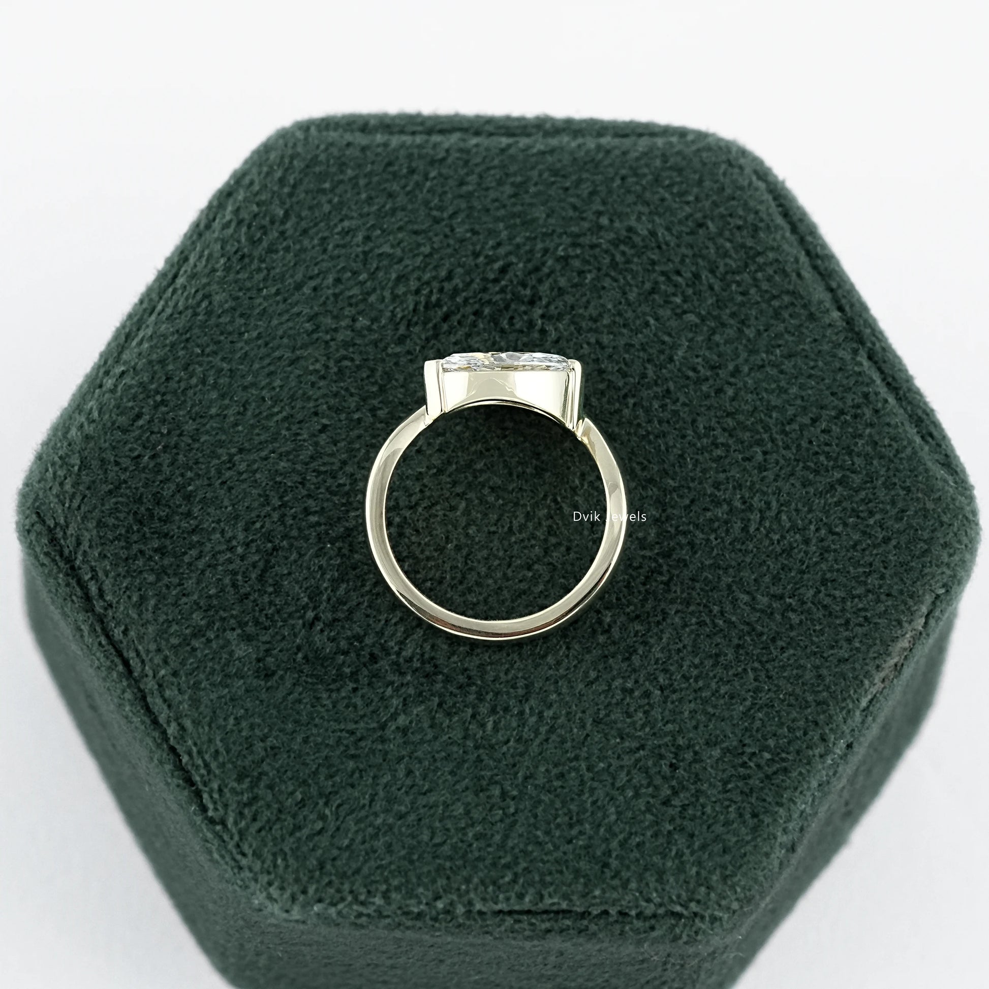 Lab Made Diamond Curved Marquise Cut Solitaire Engagement Ring held on jewelry box displaying mid-profile