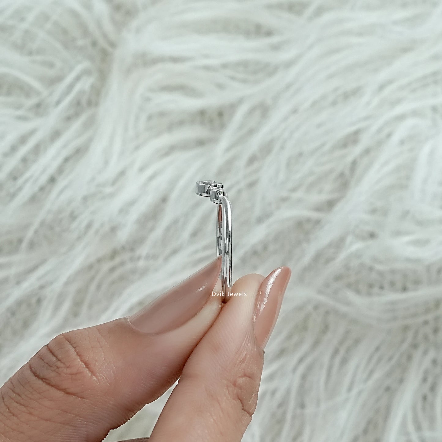 V shaped wedding band white gold held to show the unique curved design.