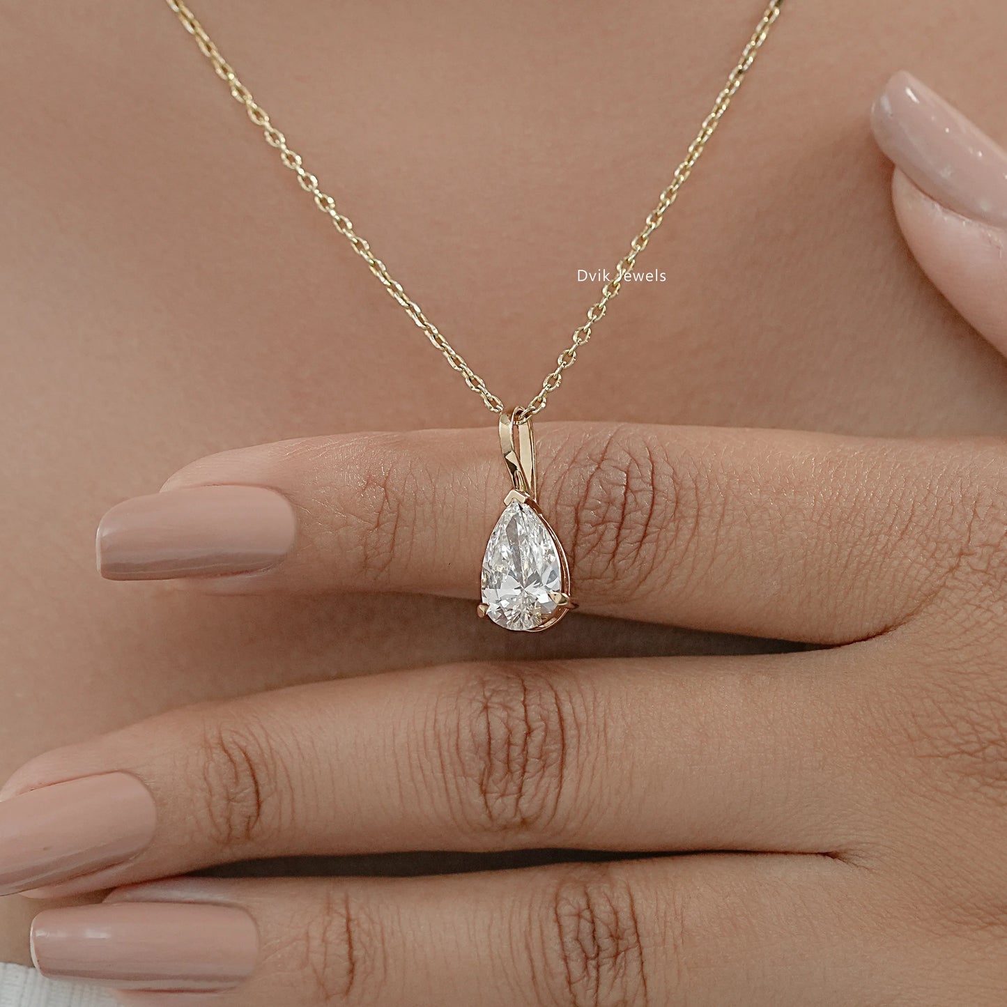 Model wearing minimalist lab grown diamond pear cut solitaire pendant to show tear-drop shape detail