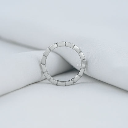 Radiant cut eternity band white gold finish on a soft fabric background