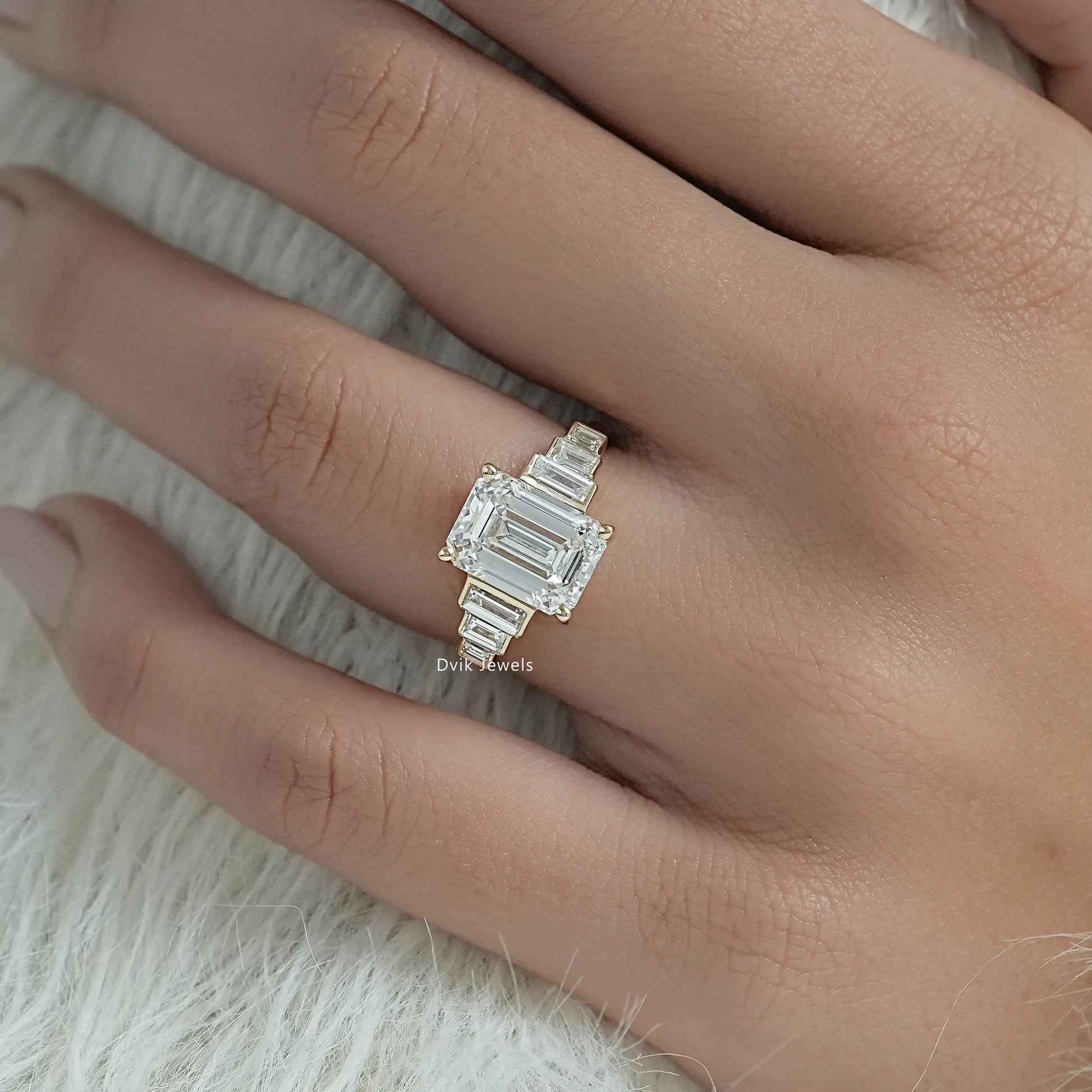 Lab grown emerald cut engagement rings featuring a modern basket setting.