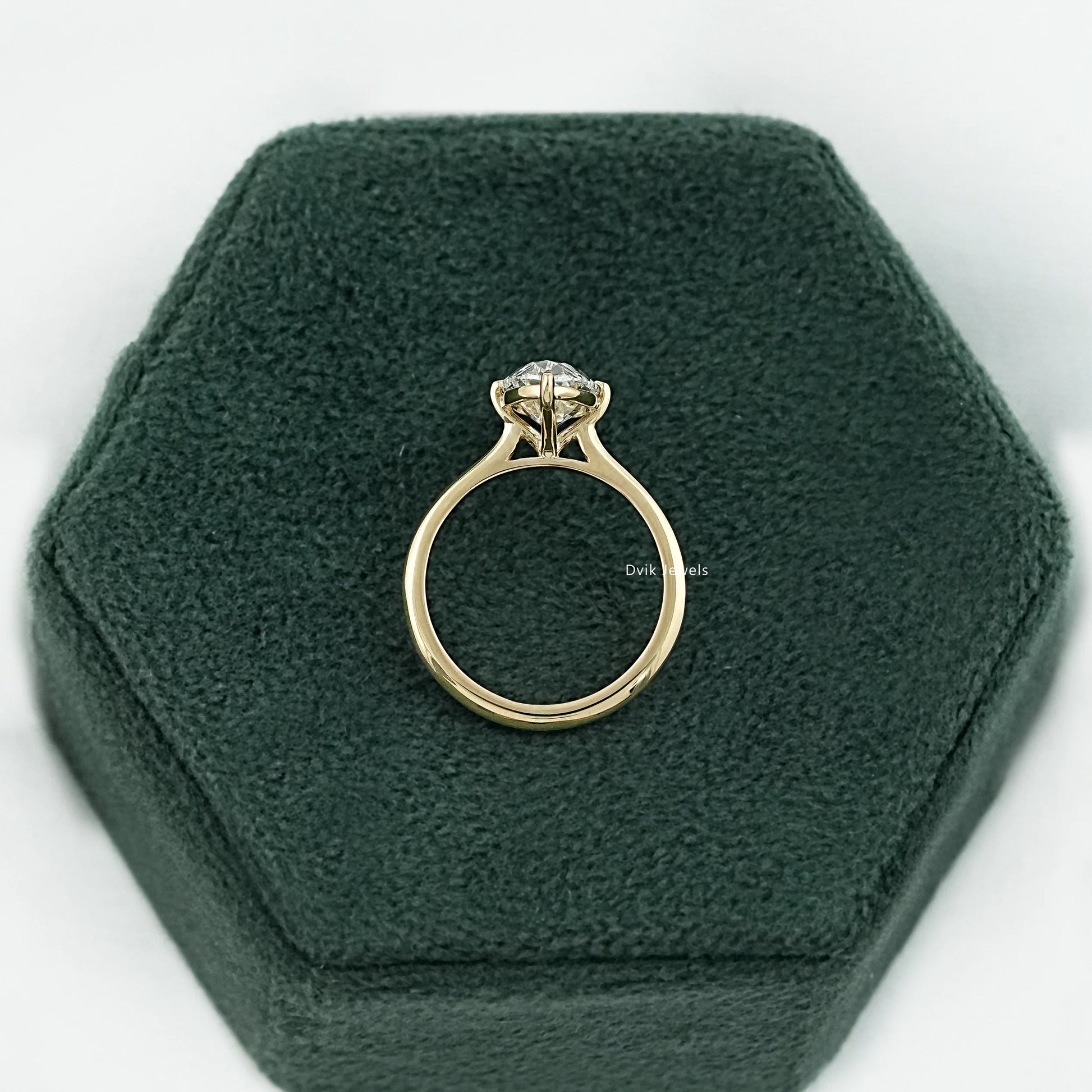 Side profile of Old Mine Moval diamond engagement ring showing basket setting and polished slim band