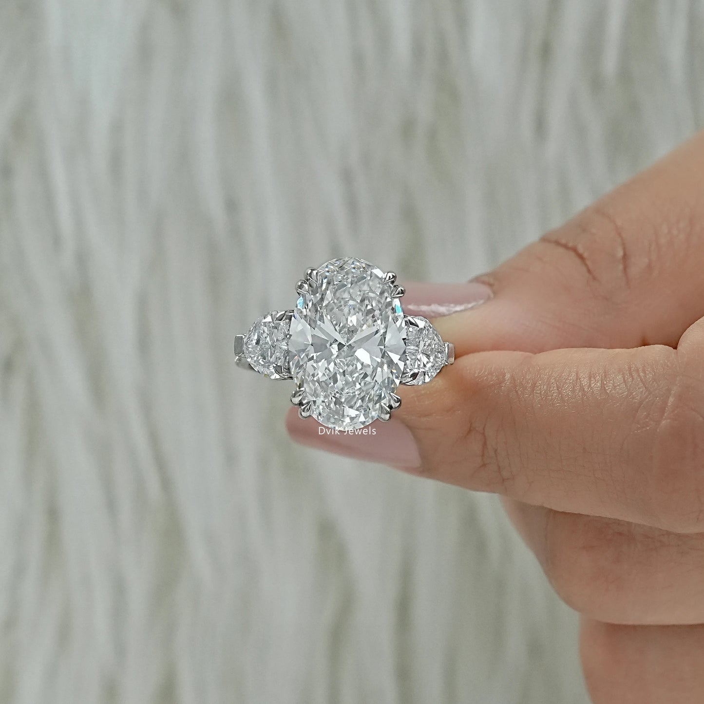 Double prong oval three stone ring oval diamond ring with side stones Finger view