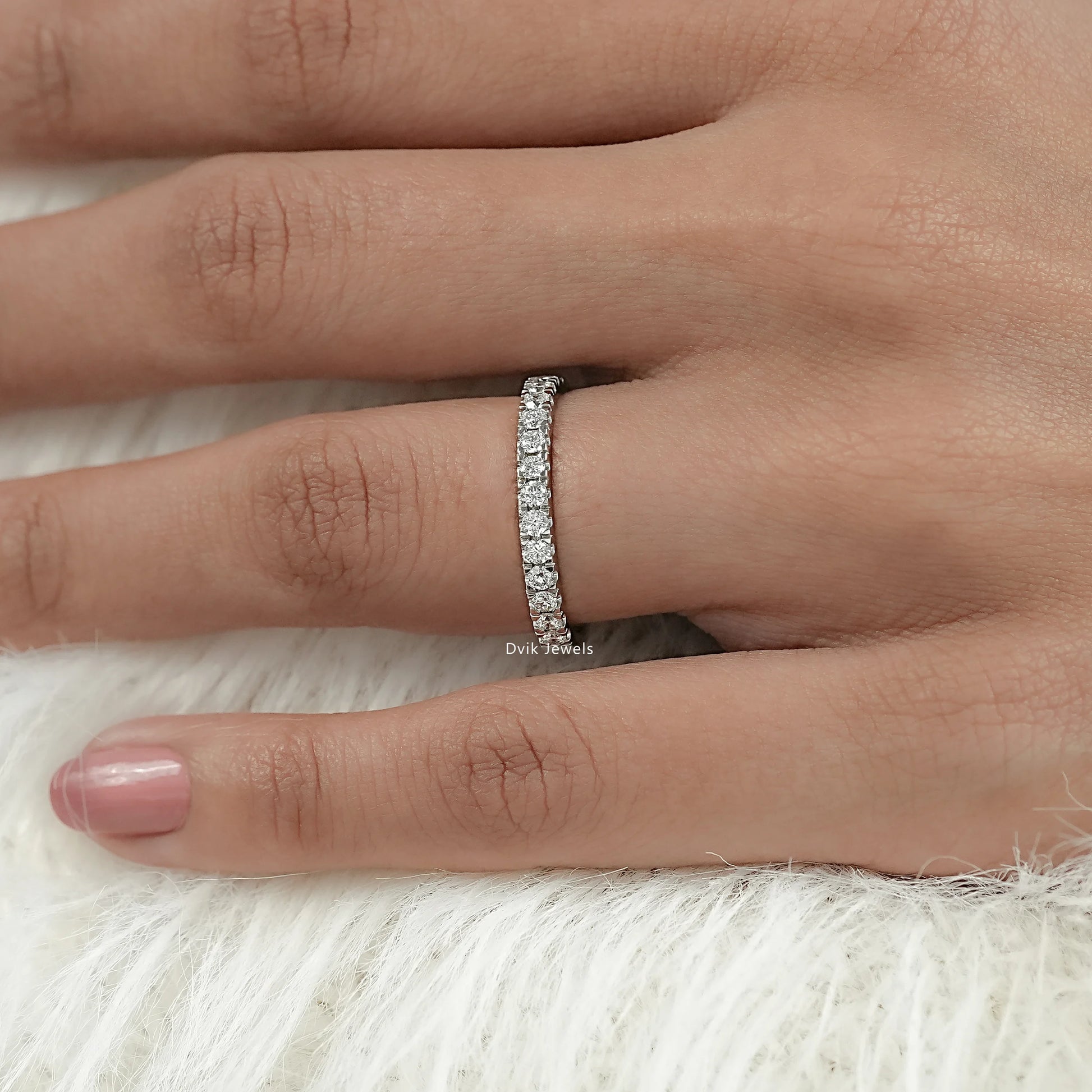 Delicate round cut half eternity band on model hand with pave setting
