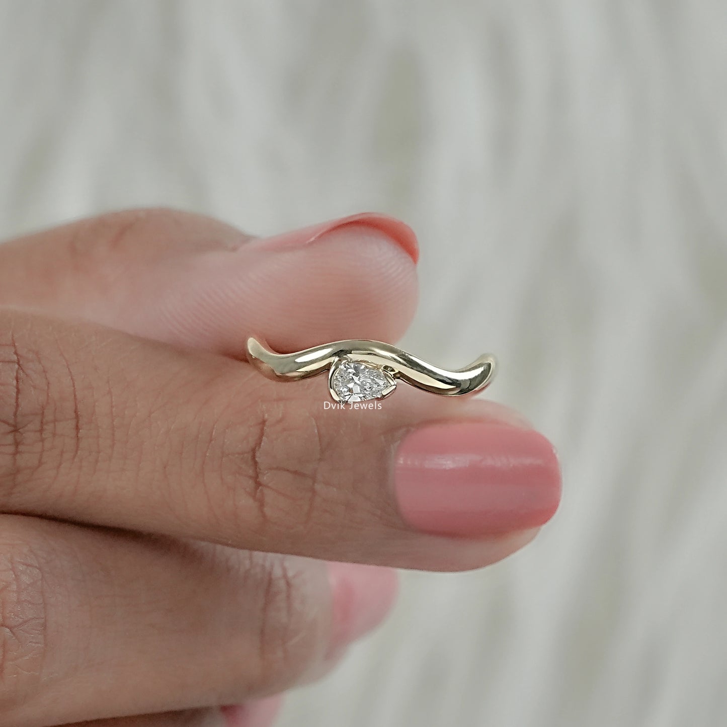 Front view of pear diamond curved engagement ring with flowing band