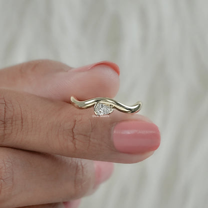 Front view of pear diamond curved engagement ring with flowing band