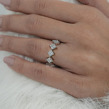 Angled view of floating diamond wedding bands on hand showcasing the unique kite-set stones.