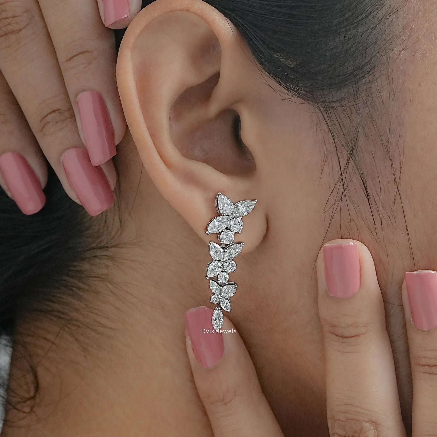 Side view of floral marquise cut drop earrings with round diamond worn on the ear