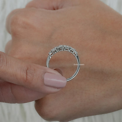 Macro view of a multi cut cluster diamond wedding band held to show detailed stone shapes.