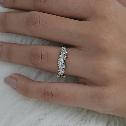 Angled hand view of a 7 stone diamond ring yellow gold showcasing heart and emerald cuts.