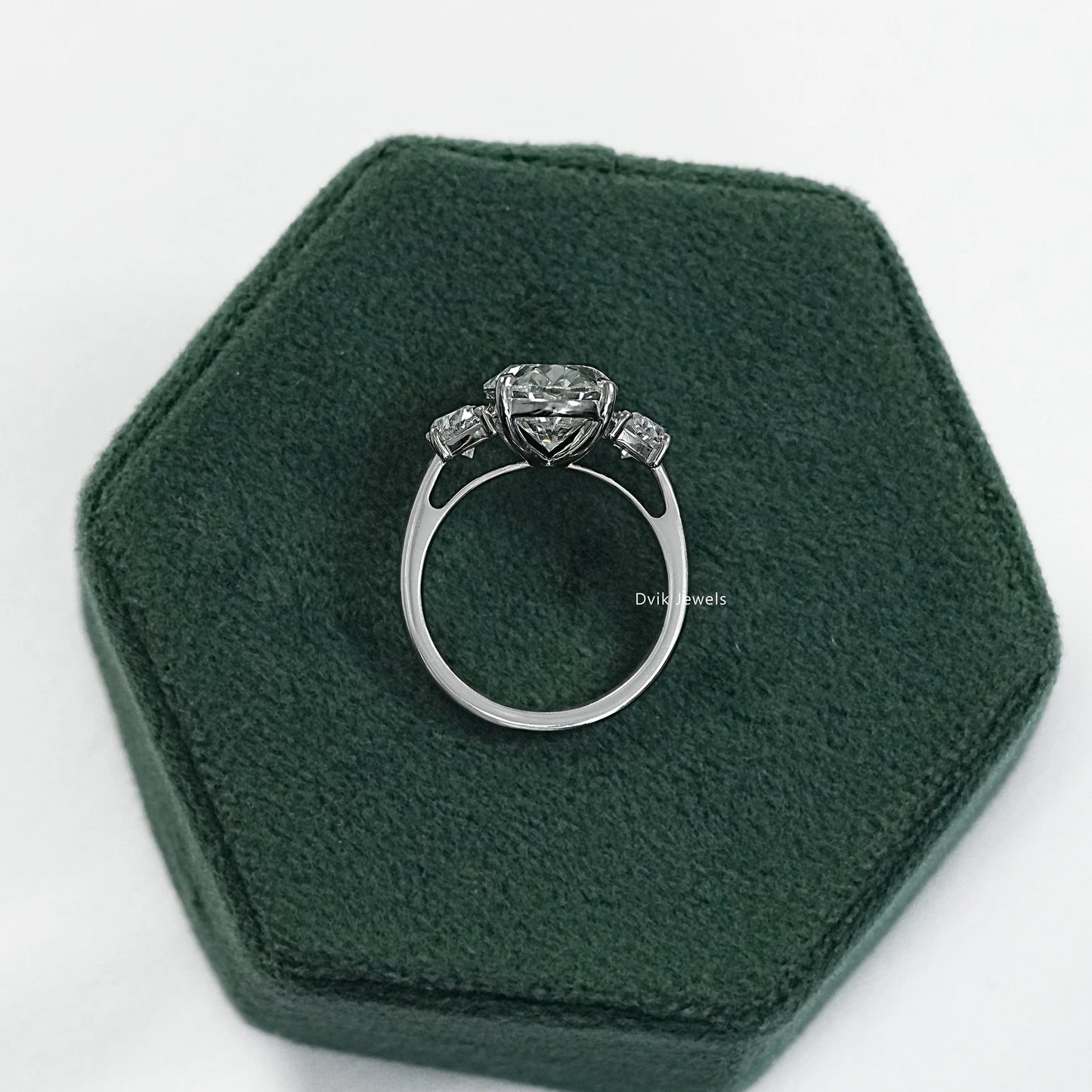 Engagement rings with half moon side stones on a clean white surface view