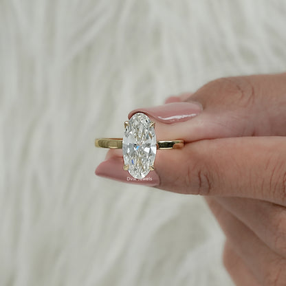 Front view of yellow gold hidden halo engagement ring with moval cut hold by women hand