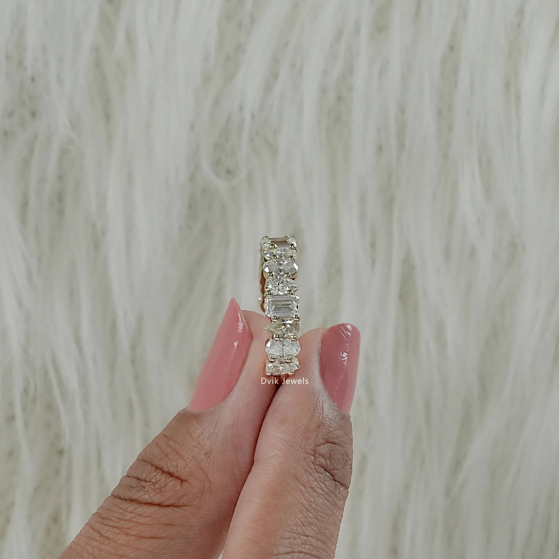 A mixed cut lab diamond eternity ring displayed on box showing various diamond facets