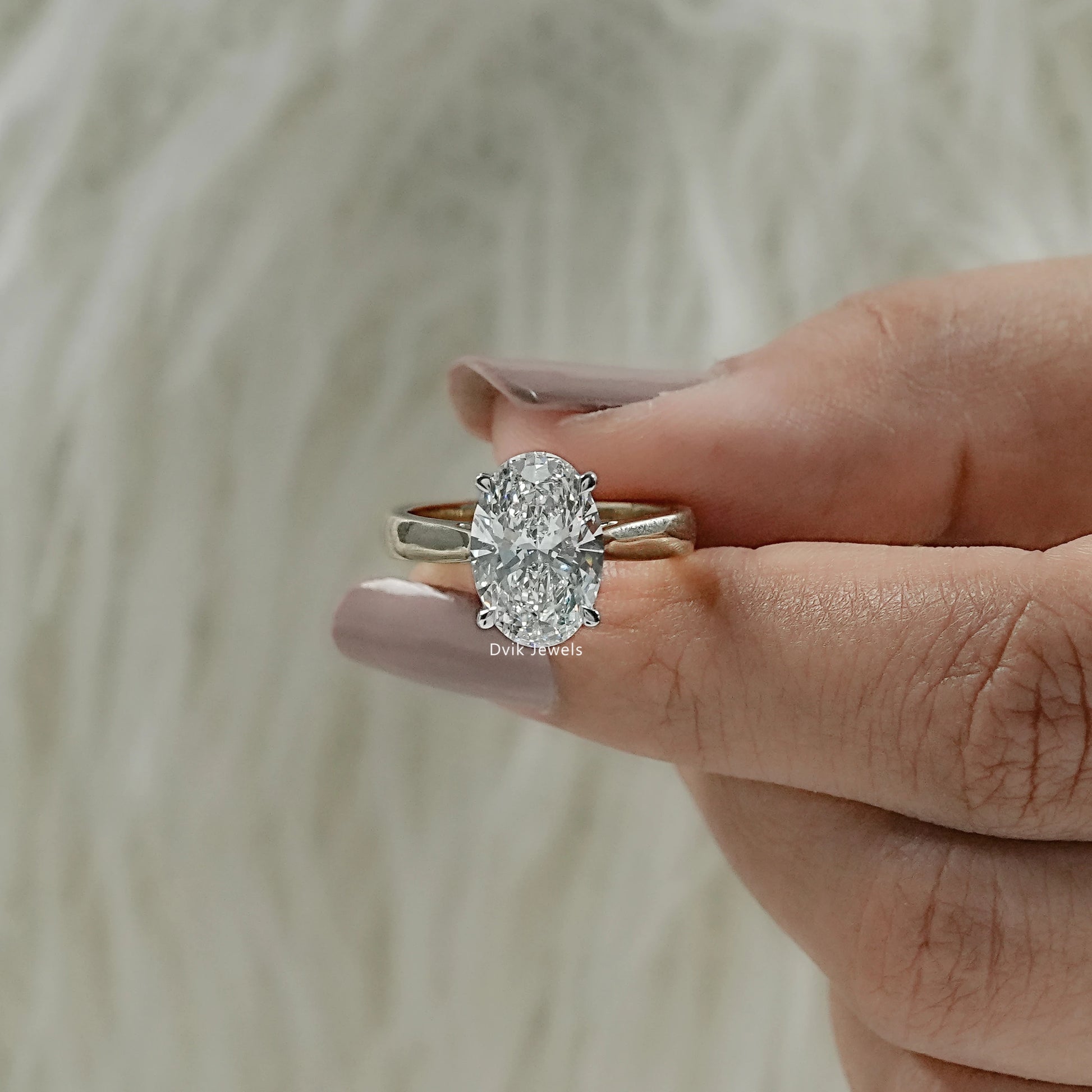 display profile view of lab grown diamond oval engagement rings, showing the solid gold band finish.