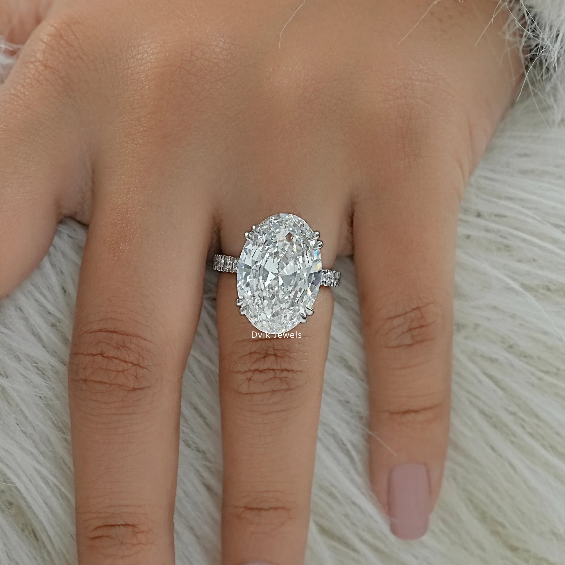 oval engagement ring worn on a finger to showcase the large scale