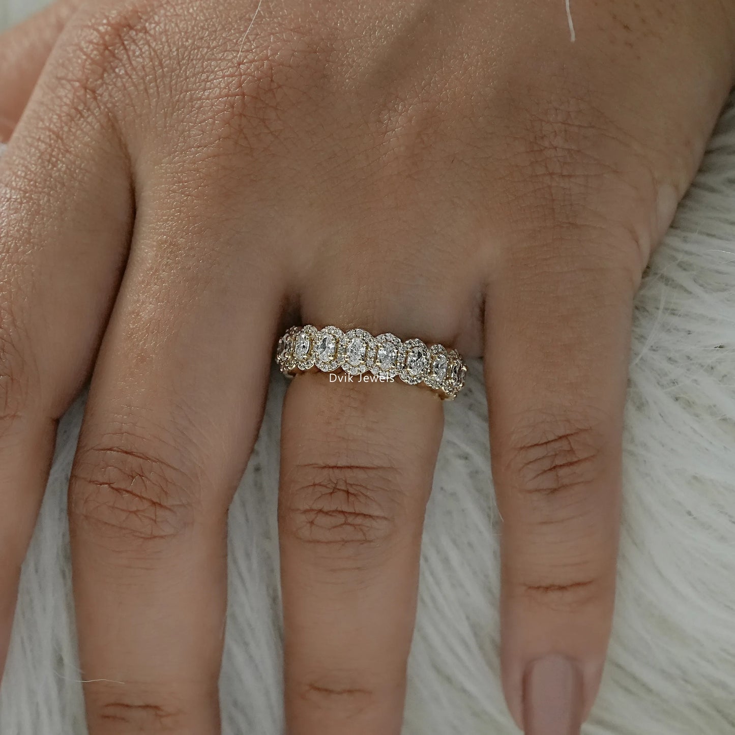 Oval halo eternity band worn as a luxury bridal diamond ring.