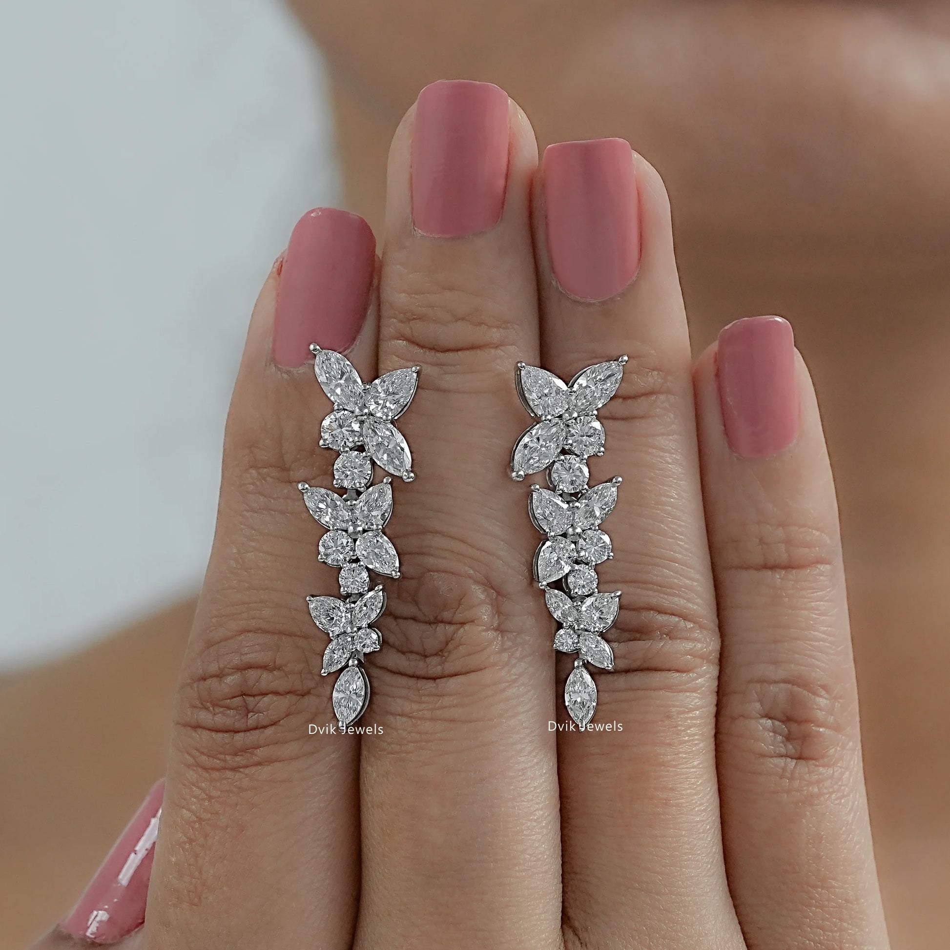 Marquise cut cluster earrings with gia certified lab diamond resting on fingers