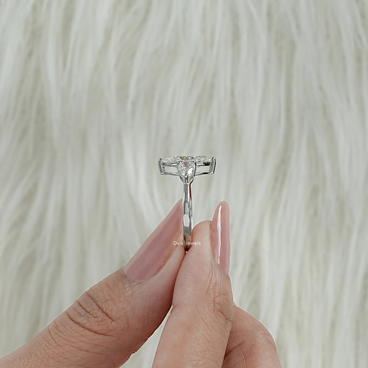 Marquise Cut Lab Diamond Three Stone Engagement Ring shown from side angle held by woman