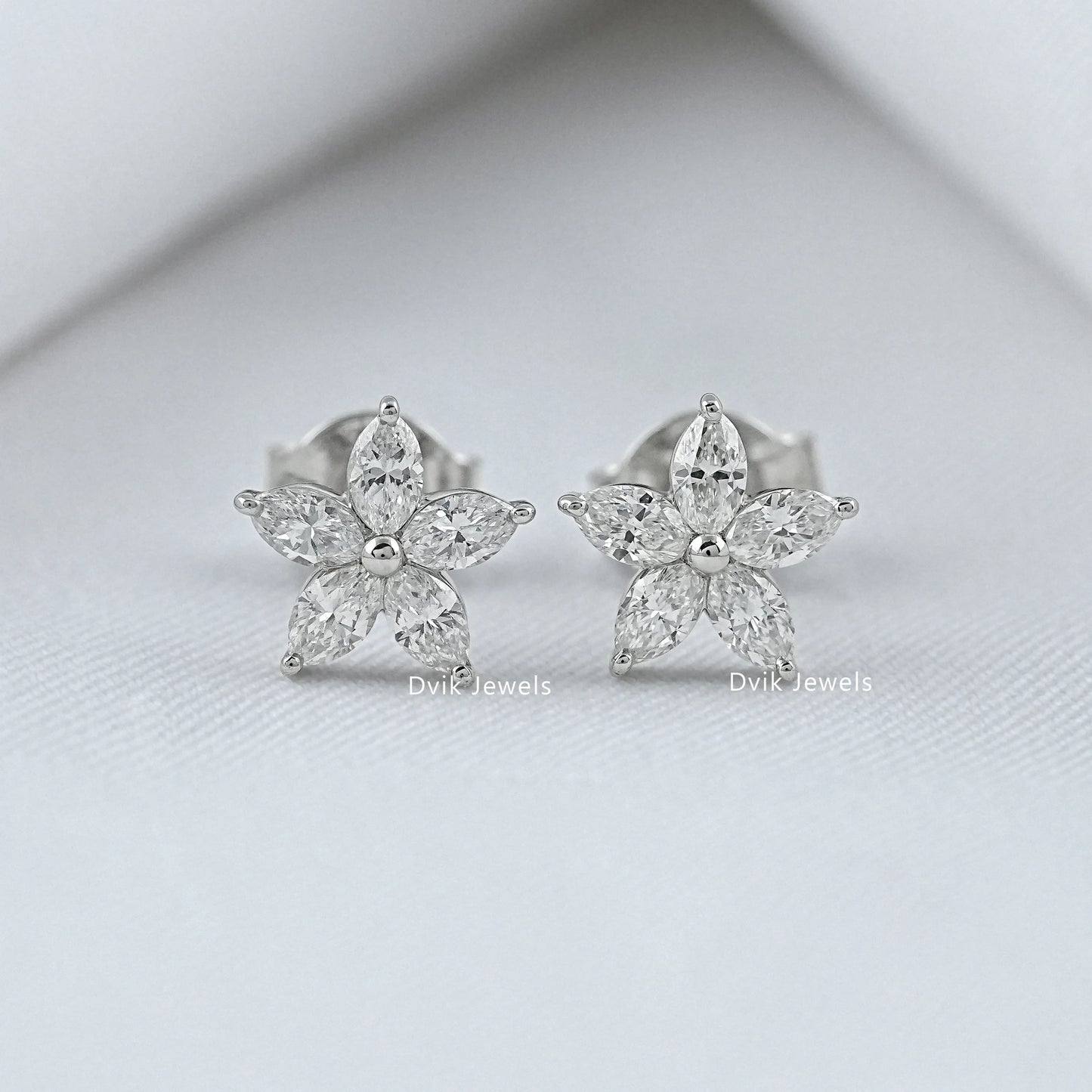 Front view of diamond flower earrings in silver and white gold