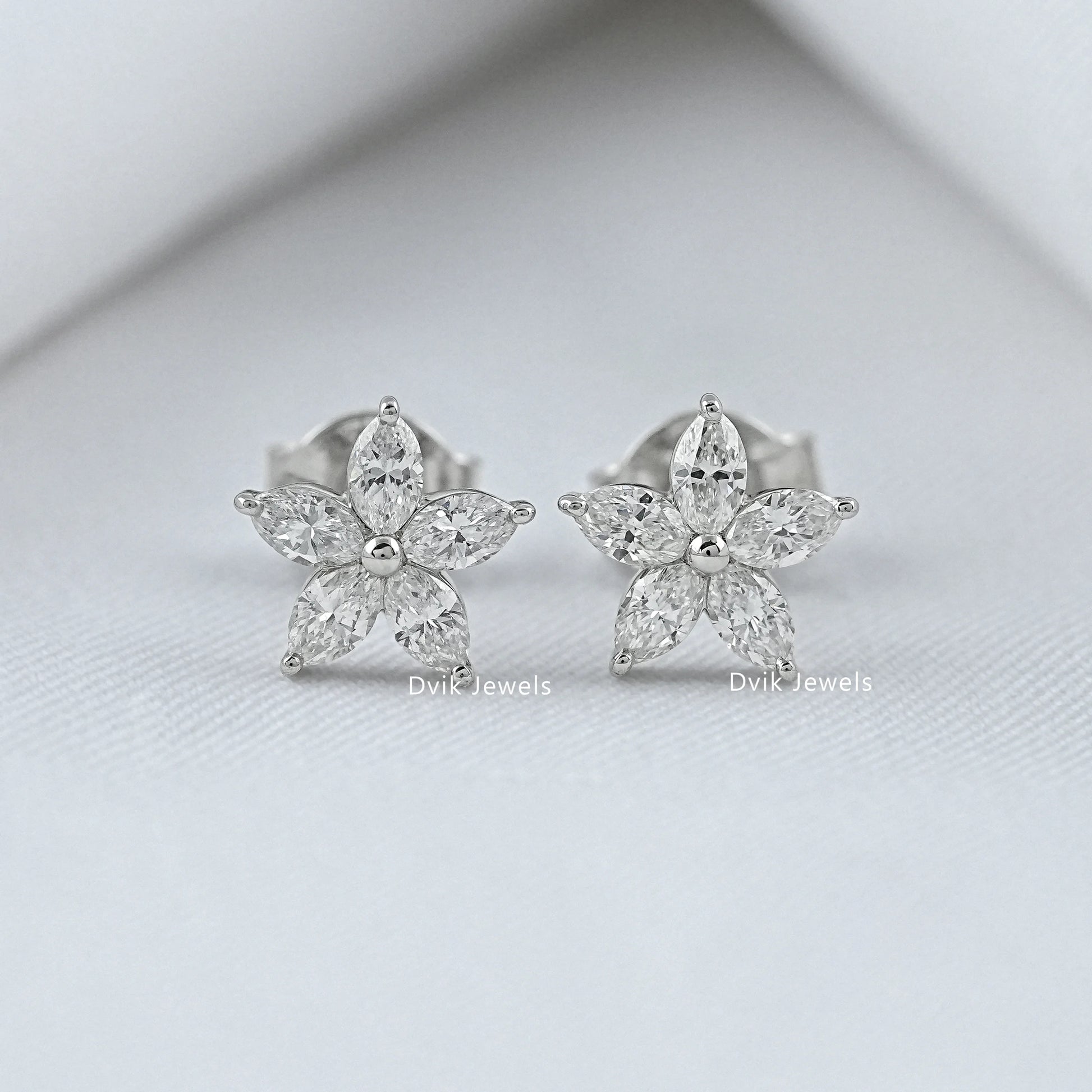 Front view of diamond flower earrings in silver and white gold