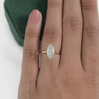 Modern marquise diamond engagement ring in yellow gold worn by women