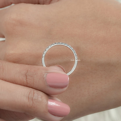 Minimal round diamond half eternity wedding band held by women for middle view