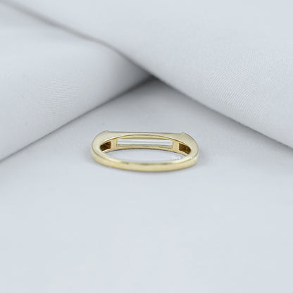 Baguette diamond engagement ring held to show the high quality metal band