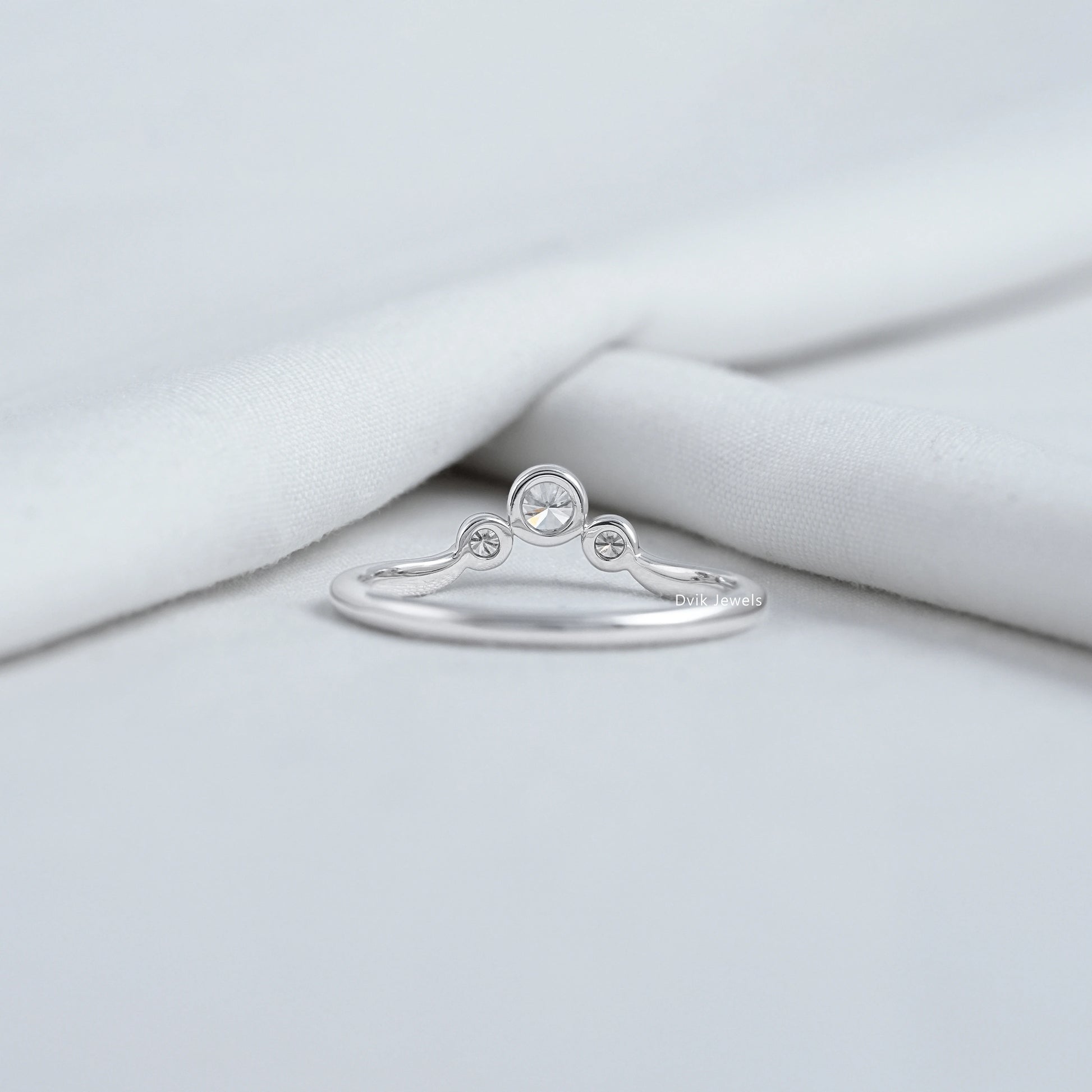 Curved bezel trilogy rings with sparkling lab diamonds in white gold.