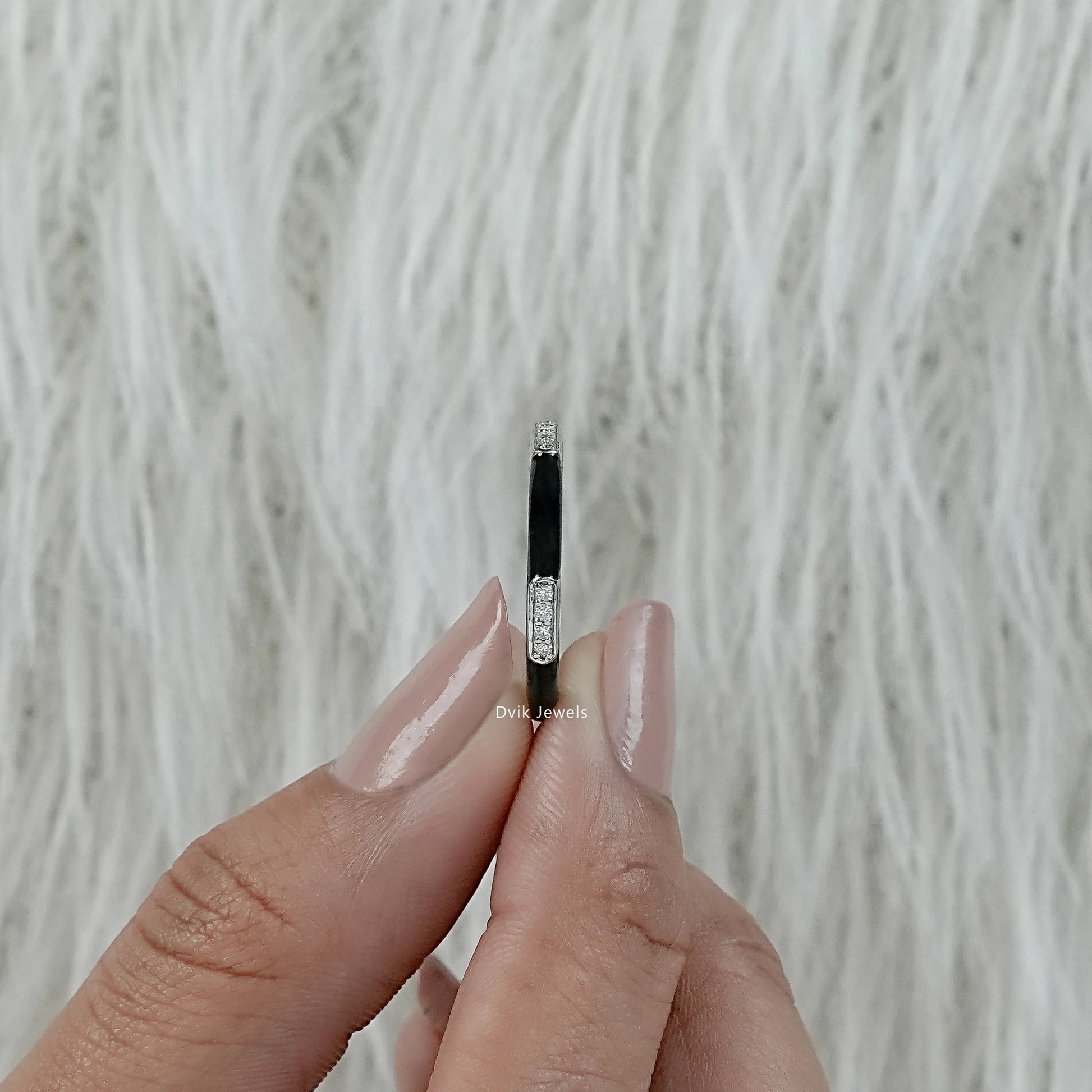 Black enamel wedding band white gold diamond bar held in hand