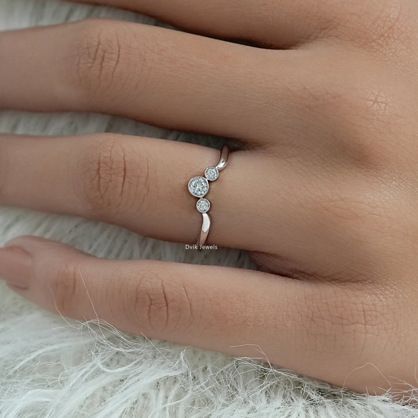 Round trilogy ring showcasing three brilliant cut diamonds on a hand.