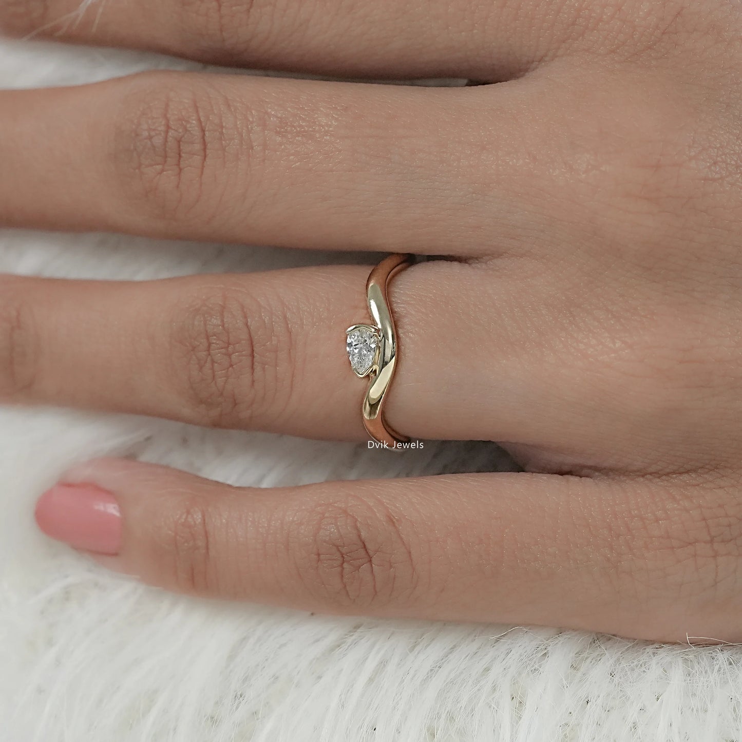 Pear cut engagement ring with wave/curved contour band on model hand