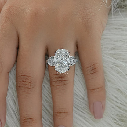 Three stone oval diamond engagement ring on finger top view