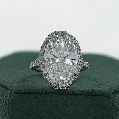 Oval halo pave engagement ring held to show the shimmering diamond border